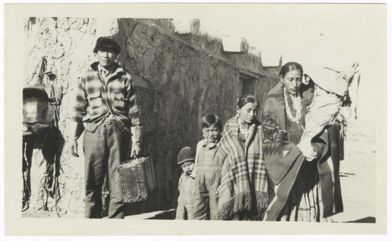 Man, Woman and Four Children in front of a Building
