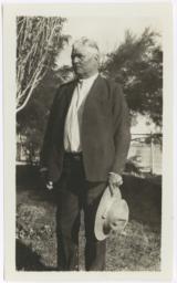 Older Native American Man in Suit, with a Hat in His Hands