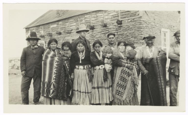 Group of Men, Women and Children Standing in Front of a Building