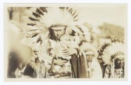 Men in Full Native American Regalia, front Man Holds an Infant Tenderly