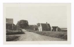 View Down a Dirt Road with Wood Buildings, Maine