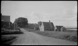 View Down a Dirt Road with Wood Buildings, Maine