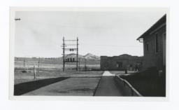 Unidentified Buildings, Electrical Wires Grid and Mountains in the Background