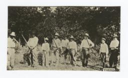 Group of Men Lined up with Bows and Arrows, Man on Left of Frame Points toward a Target 