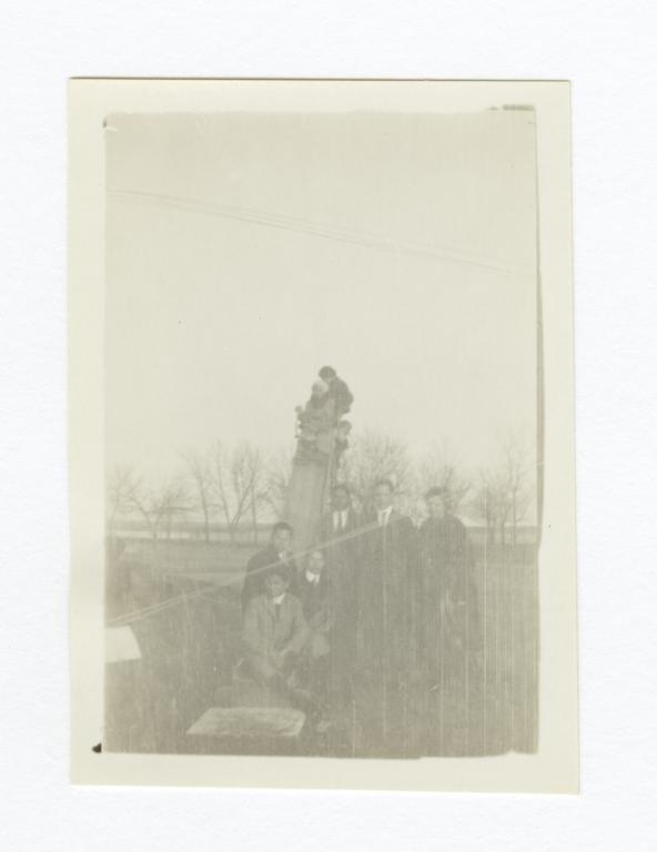 Group of Men and Children Outside Gathered around or on a Slide