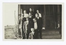 Group of People Standing on the Steps Leading to a Porch