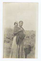 American Indian Woman Carrying a Young Child on Her Back 