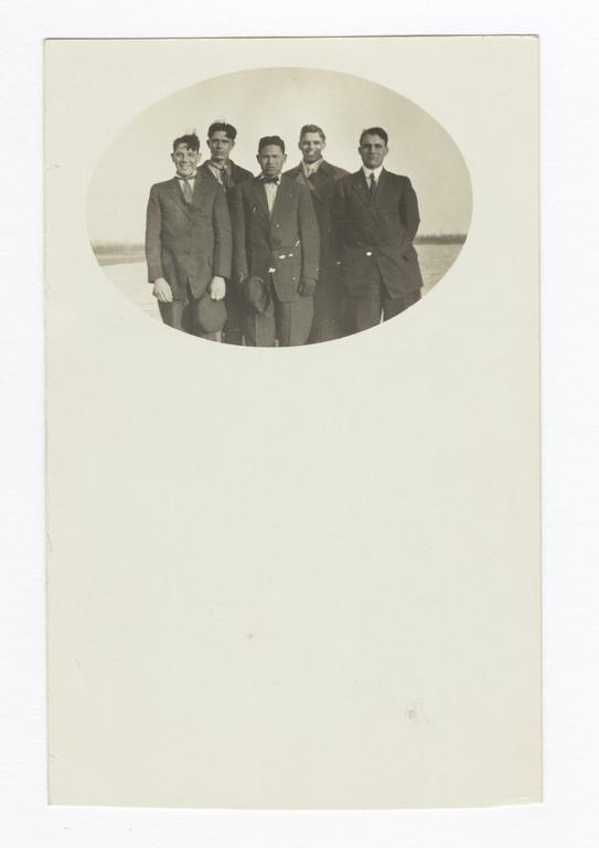 Five Men Standing in a Field Wearing Suits and Ties