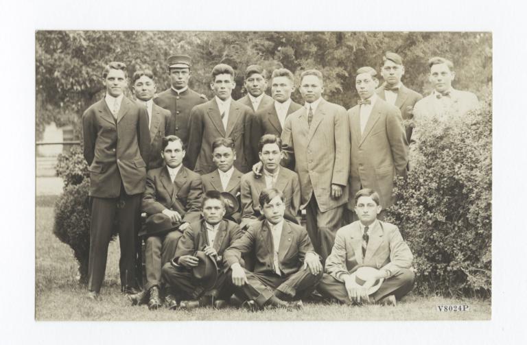 Group of Men Posing between Two Small Shrubs 
