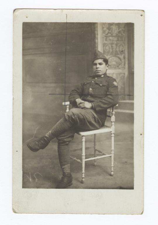 Man Wearing a Uniform and Sitting with Legs Crossed in a Chair