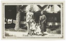 G.E.E. Lindquist with Woman and Two Children Posing in front of a House
