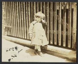 Child Beside a Wooden Fence