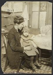 Woman Holding Child Near Table
