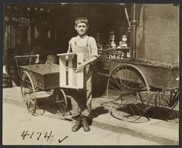 Boy with Box near Empty Pushcarts