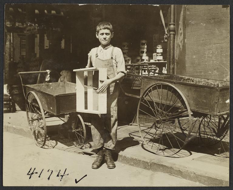 Boy with Box near Empty Pushcarts