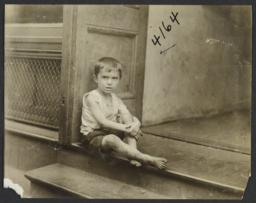 Boy Sitting at Entrance to Building