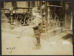 Boy Standing near Wrought Iron Railings
