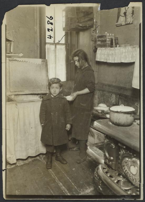 Two Children in Kitchen with Birdcage