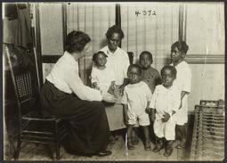 Columbus Hill Health Center Album -- Woman and Four Children with Nurse