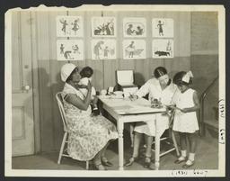 Columbus Hill Health Center Album -- Nurse with Mother and Children at Columbus Hill Health Center
