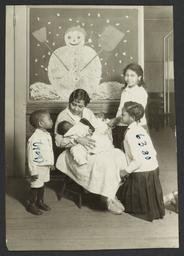 Columbus Hill Health Center Album -- Nurse with Children in front of Snowman Painting