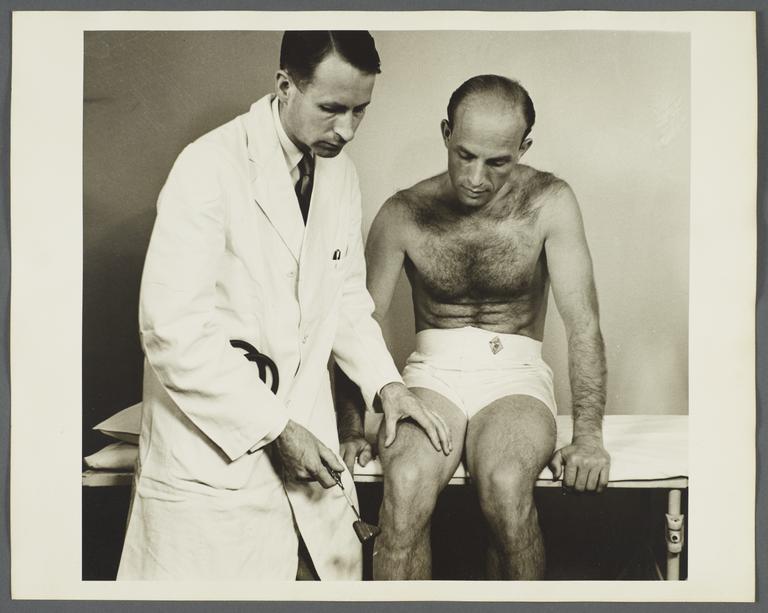 Health Examination-Men Album -- Doctor Checking Man's Reflexes.