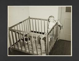 Picturing Some of the Principles of Child Care Album -- Baby Standing Up in Playpen