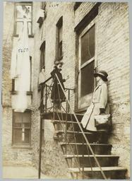 Mulberry Health Center Album -- Visiting Nurse on Tenement Back Stairs